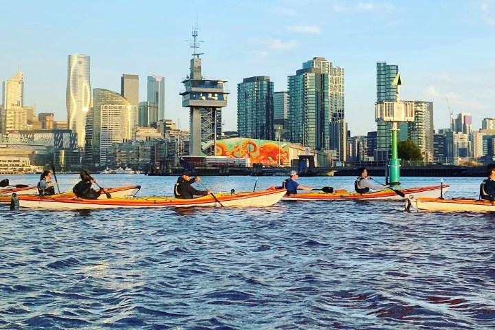 a small boat in a body of water with a city in the background